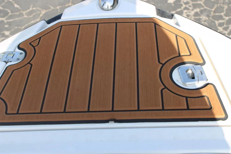 Slide: The Image of 2013 Monterey 234 SS boat deck with wood finish and metal latch. - 13