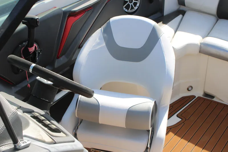 Slide: The Image of 2013 Monterey 234 SS boat interior with white captain's chair and steering wheel. - 28