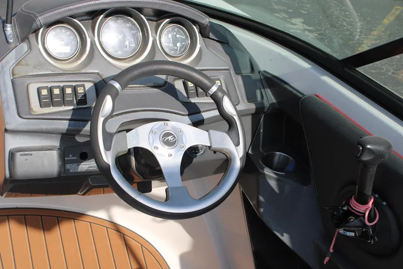 Slide: The Image of 2013 Monterey 234 SS boat dashboard with steering wheel and controls. - 30