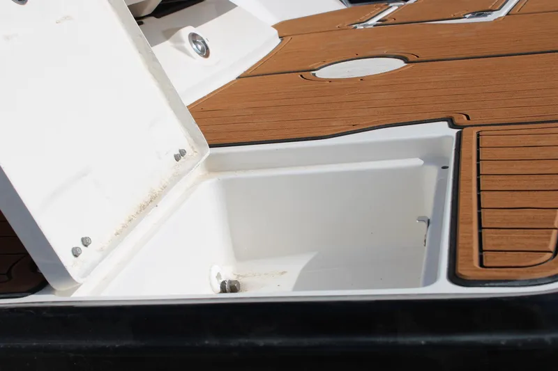 Slide: The Image of Open storage compartment on 2013 Monterey 234 SS boat with teak flooring. - 35