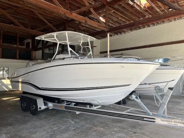 Slide: The Image of 2024 Jeanneau Leader 7.5 CC Series 3 boat on trailer in a marina. - 0