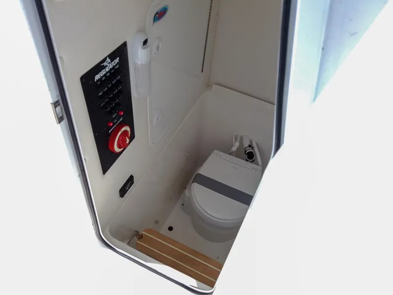 Slide: The Image of 2025 Regulator 23 Center Console boat interior with marine toilet and control panel. - 15