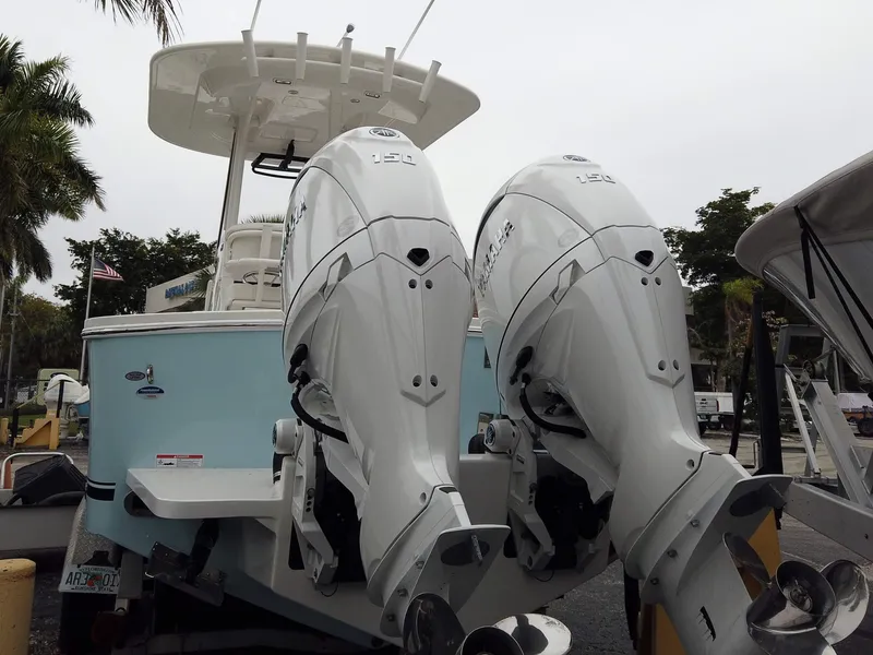 Slide: The Image of 2025 Regulator 23 Center Console with dual outboard engines, docked outdoors. - 19