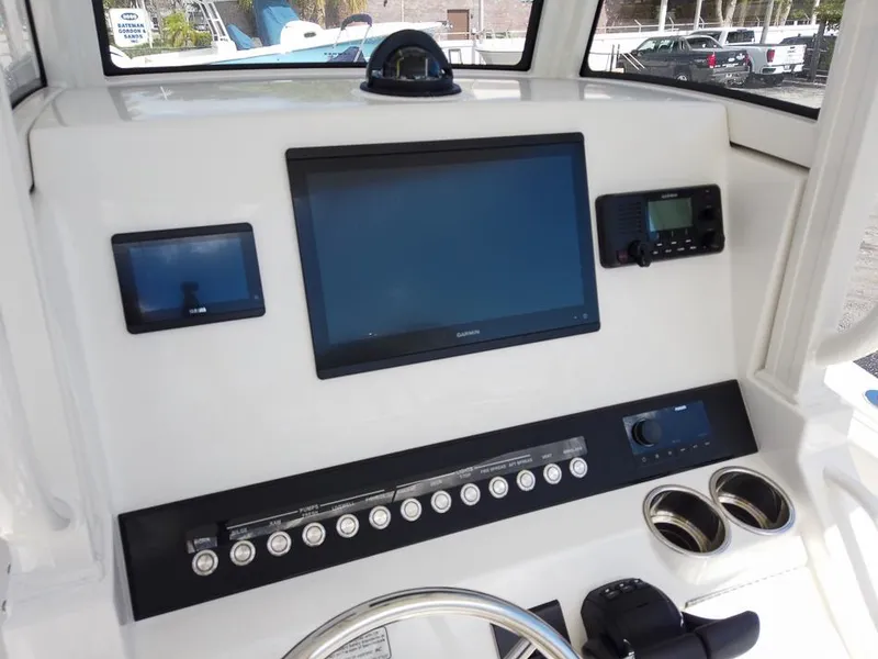 Slide: The Image of 2025 Regulator 23 Center Console boat dashboard with navigation screens and controls. - 2