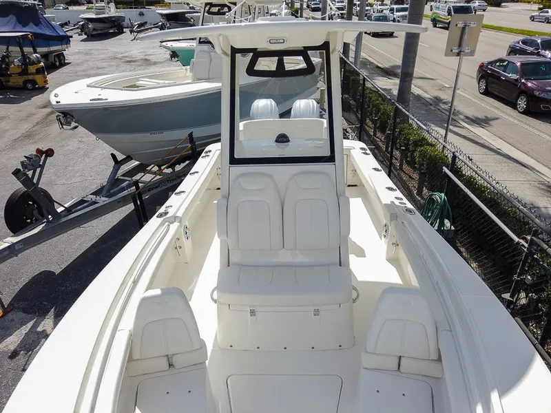 Slide: The Image of 2025 Regulator 23 Center Console boat with white seating and console, docked at a marina. - 3
