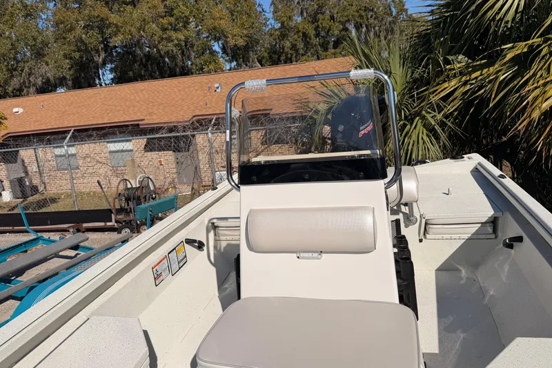 Slide: The Image of 2026 Ranger RB190 boat interior with console and seating, surrounded by trees and a building. - 6