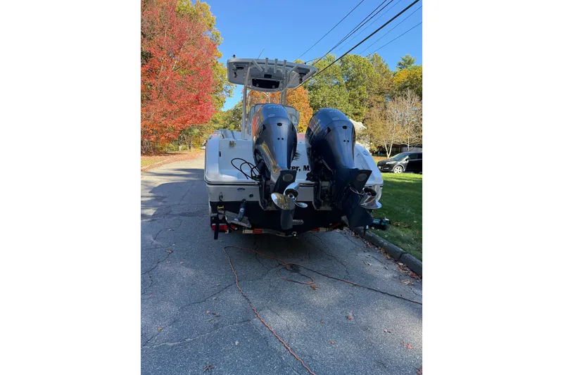 Slide: The Image of 2017 Century 2600 CC boat with dual outboard motors on a tree-lined street. - 6