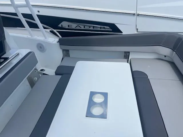 Slide: The Image of 2024 Jeanneau Leader 9.0 WA boat interior seating and table area. - 3