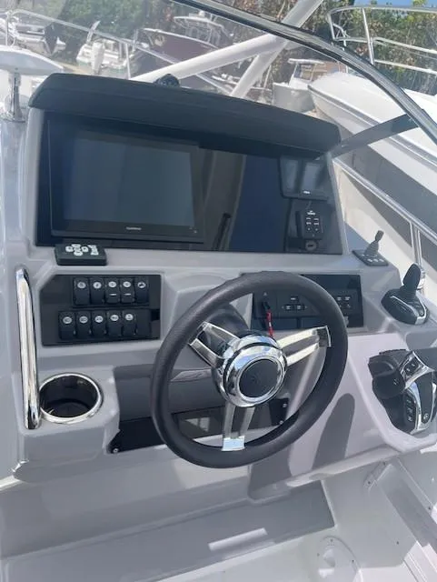 Slide: The Image of 2024 Jeanneau Leader 9.0 WA helm station with modern controls and navigation system. - 5