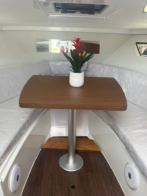 Slide: The Image of Interior of 2024 Jeanneau Leader 9.0 WA with a wooden table and potted plant. - 6