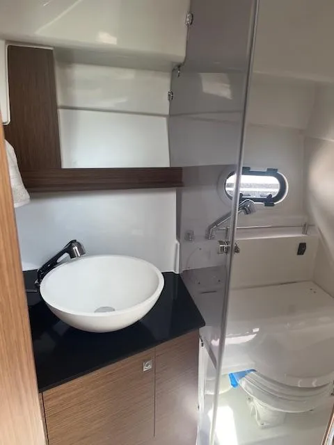 Slide: The Image of 2024 Jeanneau Leader 9.0 WA bathroom with modern sink and porthole window. - 8