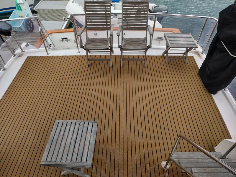 Slide: The Image of Spacious deck of 1989 Ocean Alexander 440 CPMY with wooden chairs and table. - 26