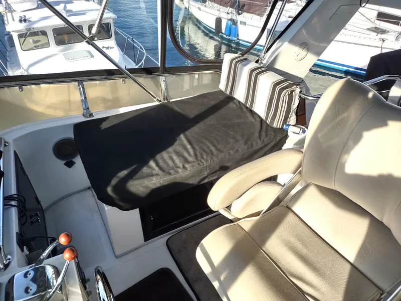 Slide: The Image of Cockpit view of 1989 Ocean Alexander 440 CPMY yacht with leather seats and striped cushions. - 37