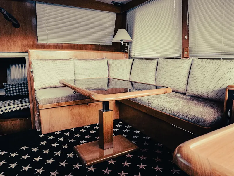 Slide: The Image of Interior of 1989 Ocean Alexander 440 CPMY yacht with cushioned seating and wooden table. - 49