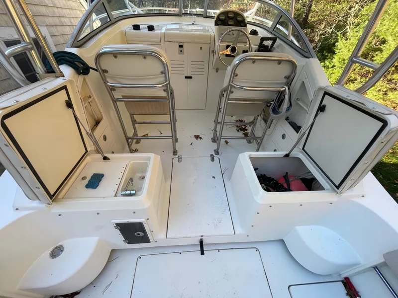 Slide: The Image of 2003 Scout 280 Abaco boat interior with open storage compartments and helm. - 11
