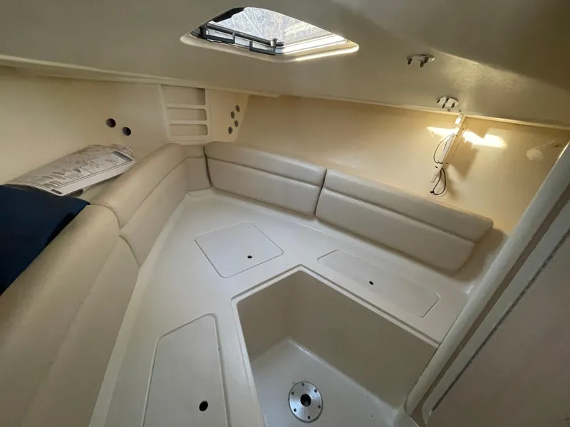 Slide: The Image of Interior cabin of 2003 Scout 280 Abaco boat, featuring beige seating and overhead lighting. - 19