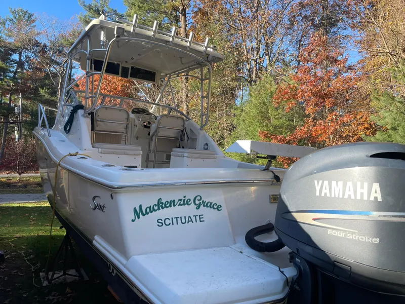 Slide: The Image of 2003 Scout 280 Abaco boat with Yamaha engine, named "Mackenzie Grace," in a wooded area. - 4