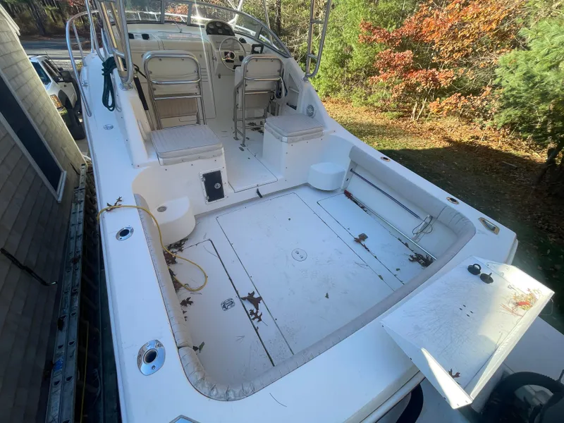 Slide: The Image of 2003 Scout 280 Abaco boat with spacious deck and seating, surrounded by autumn foliage. - 5
