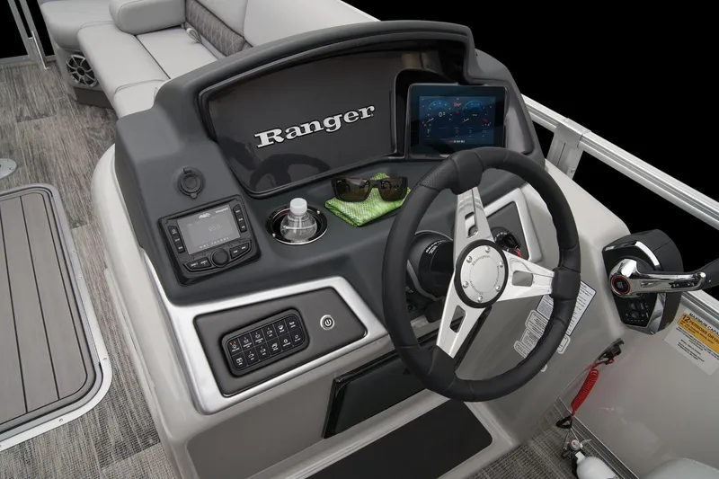 Slide: The Image of 2024 Ranger Reata 243C boat dashboard with steering wheel, control panel, and navigation screen. - 36