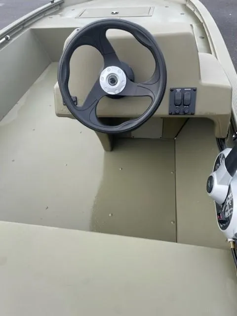 Slide: The Image of 2024 Tracker Grizzly 1648 SC boat interior with steering wheel and control panel. - 3