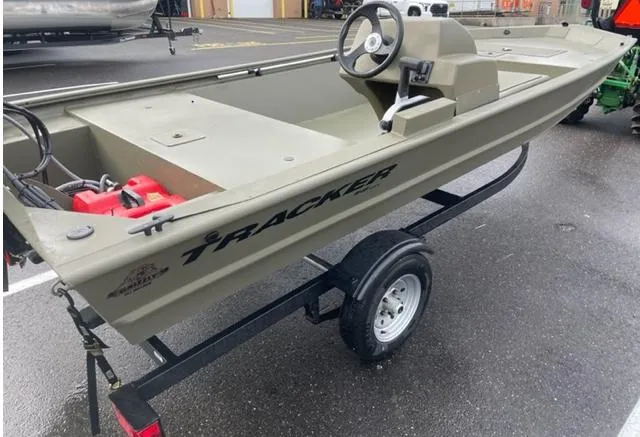Slide: The Image of 2024 Tracker Grizzly 1648 SC boat on trailer, side view, in parking lot. - 4