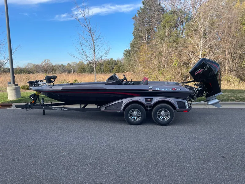 The Image of 2024 Ranger Z519 boat on trailer, parked on a road with trees in the background. - 0