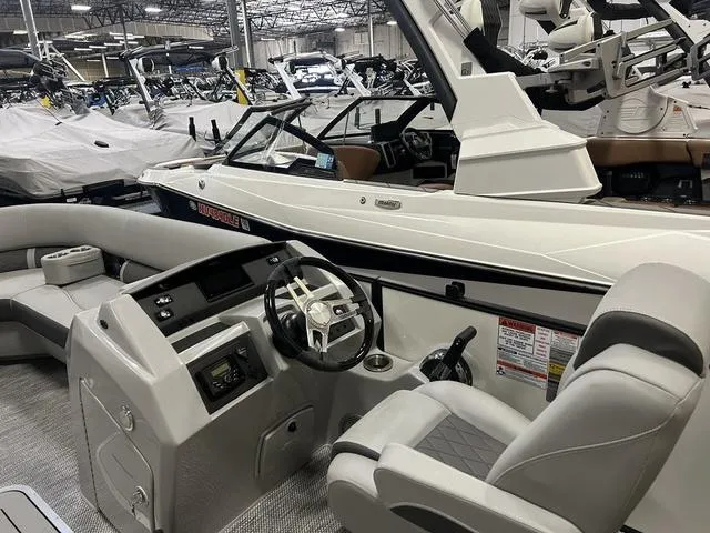 Slide: The Image of 2024 Bennington 23 LFB boat interior with modern helm and seating in showroom. - 4