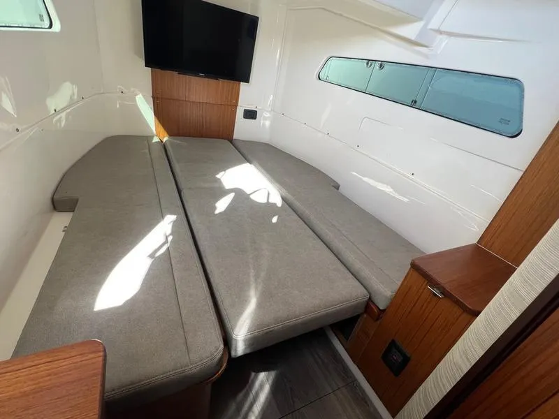 Slide: The Image of 2022 Solace 41 CS cabin interior with gray seating and wall-mounted TV. - 25