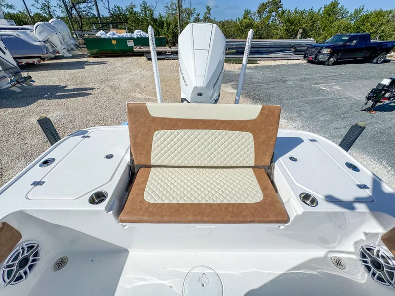 Slide: The Image of 2024 Caymas 26 HB boat with cushioned seating and outboard motor in a marina setting. - 11