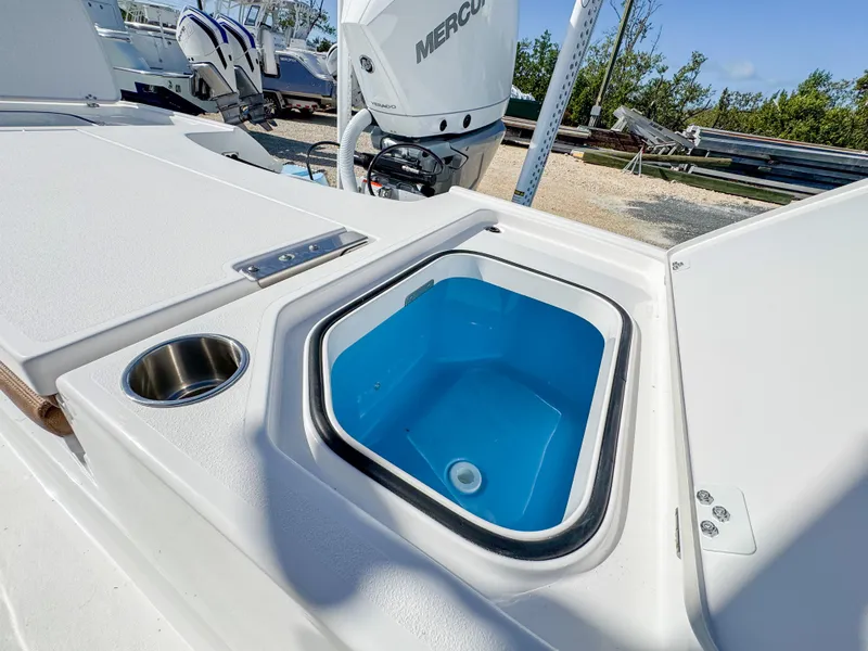 Slide: The Image of 2024 Caymas 26 HB boat with open livewell and cup holder on deck. - 14