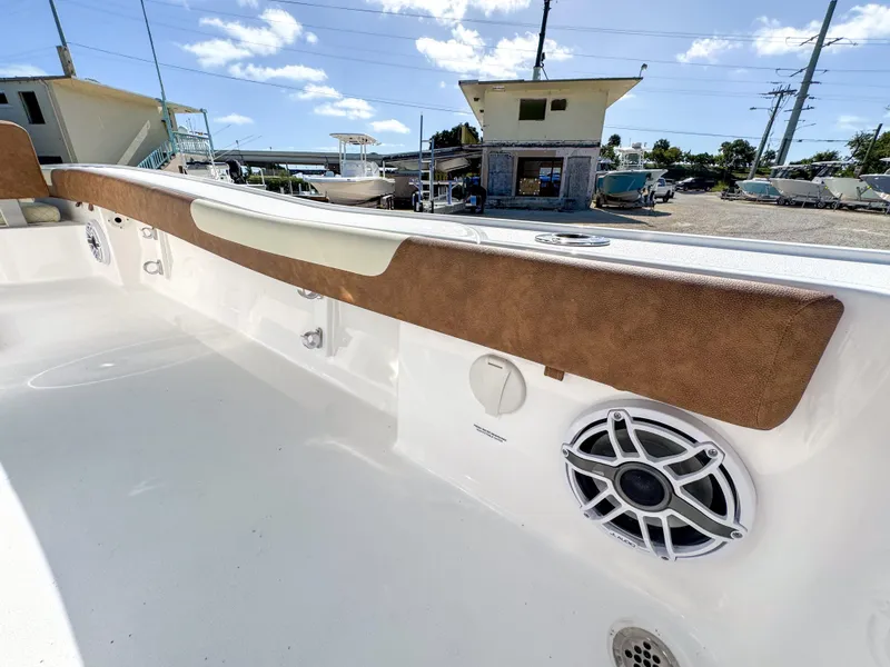 Slide: The Image of 2024 Caymas 26 HB boat interior with speaker and brown trim, docked under blue sky. - 27