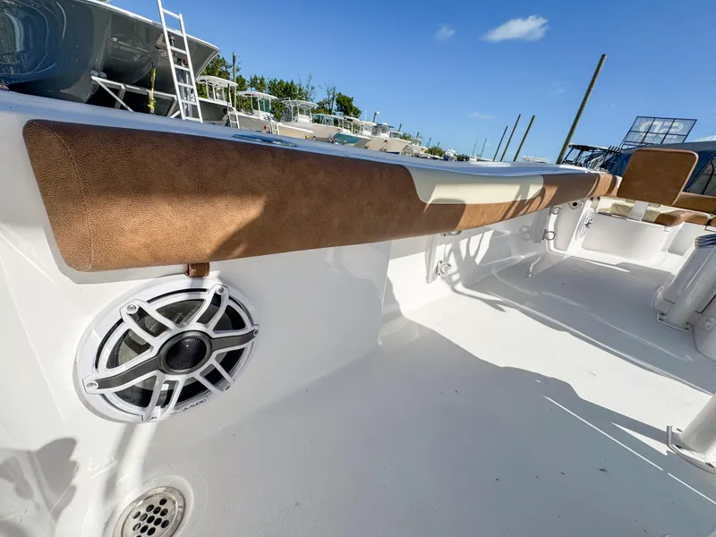Slide: The Image of 2024 Caymas 26 HB boat interior with speaker and cushioned rail under clear blue sky. - 28