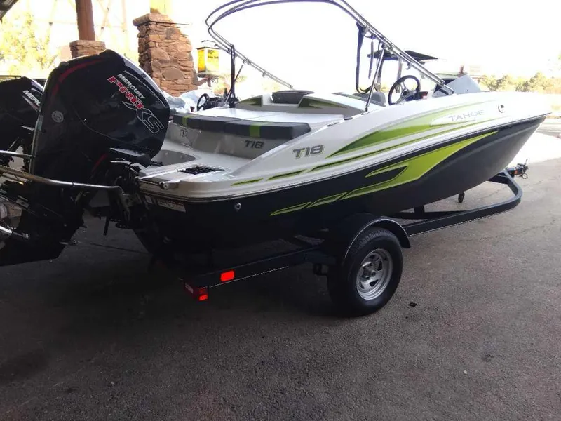 Slide: The Image of 2024 Tahoe T18 boat with outboard motor on trailer, parked indoors. - 4