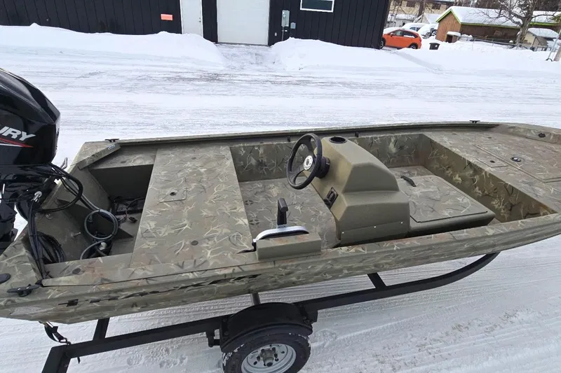 Slide: The Image of 2024 Tracker Grizzly 1648 SC boat on snowy ground, featuring camouflage design and Mercury engine. - 31