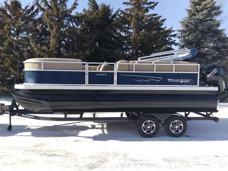The Image of 2024 Ranger Reata 200C pontoon boat on trailer, parked in snowy landscape. - 0