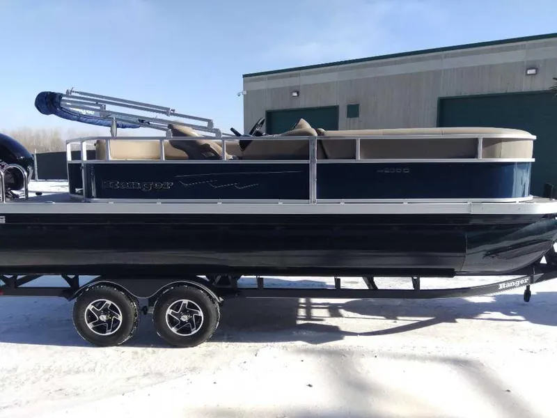 Slide: The Image of 2024 Ranger Reata 200C pontoon boat on trailer, parked outdoors. - 7