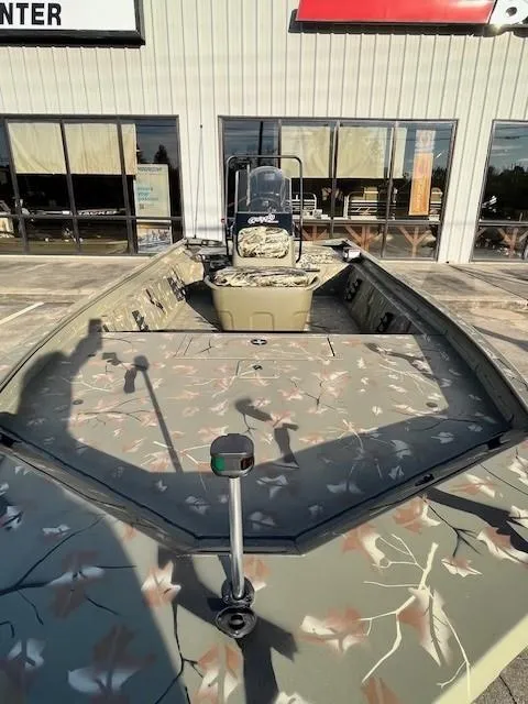 Slide: The Image of 2024 Tracker Grizzly 1860 CC boat with camouflage design, displayed outdoors. - 3