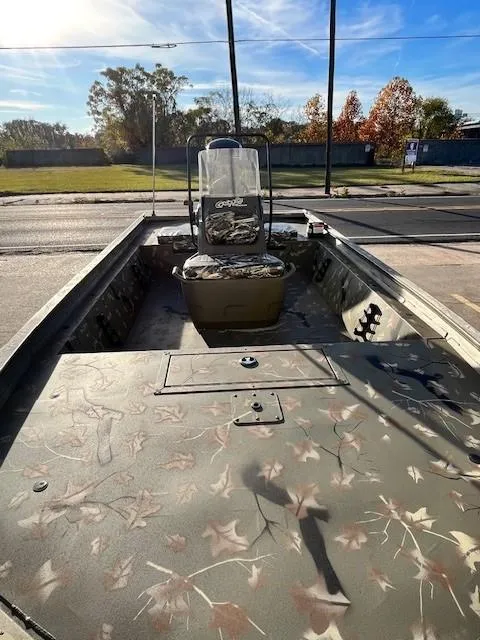 Slide: The Image of 2024 Tracker Grizzly 1860 CC boat with camouflage design, parked outdoors. - 6