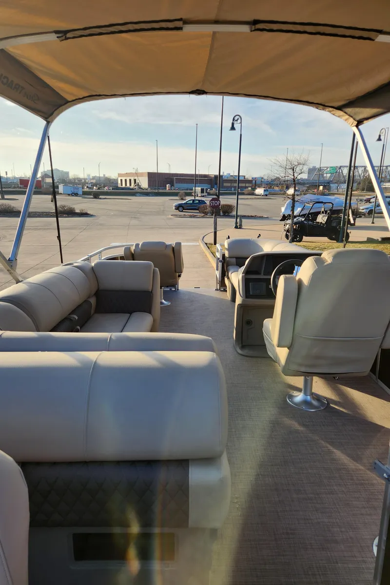 Slide: The Image of 2024 Sun Tracker SportFish 20 DLX pontoon boat interior with seating and canopy. - 2