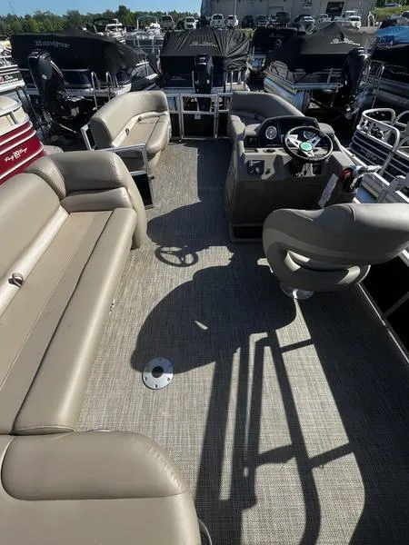 Slide: The Image of 2024 Ranger Reata 200C pontoon boat interior with beige seating and steering console. - 5