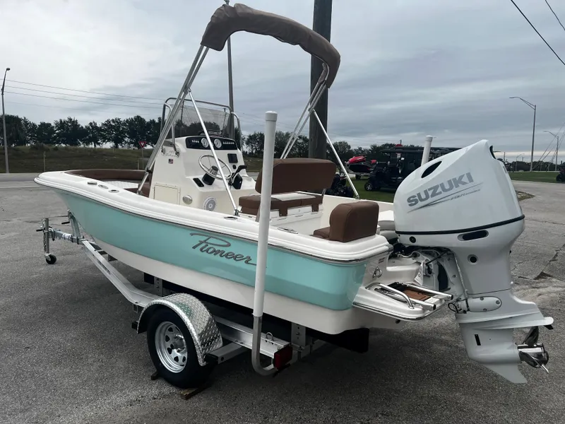 Slide: The Image of 2025 Pioneer 180 Islander boat with Suzuki outboard motor on a trailer. - 4