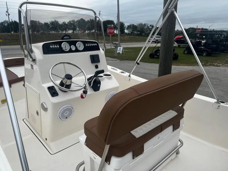Slide: The Image of 2025 Pioneer 180 Islander boat interior with steering console and brown seating. - 8