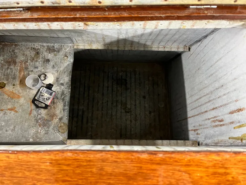 Slide: The Image of 1963 Lyman Sportsman storage compartment with metal interior and small items inside. - 13