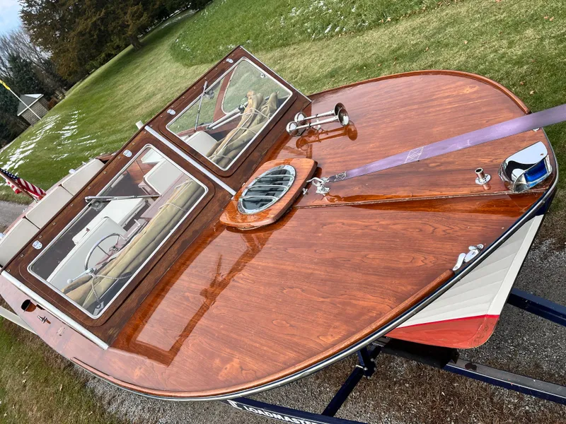 Slide: The Image of 1963 Lyman Sportsman boat with polished wood deck and dual windshields, displayed outdoors. - 2