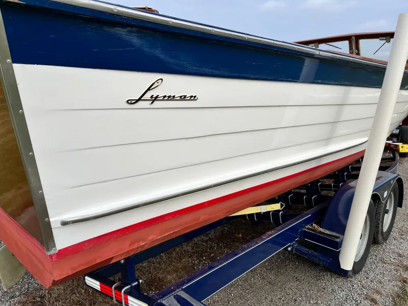 Slide: The Image of 1963 Lyman Sportsman boat on trailer, featuring classic blue and white design. - 6