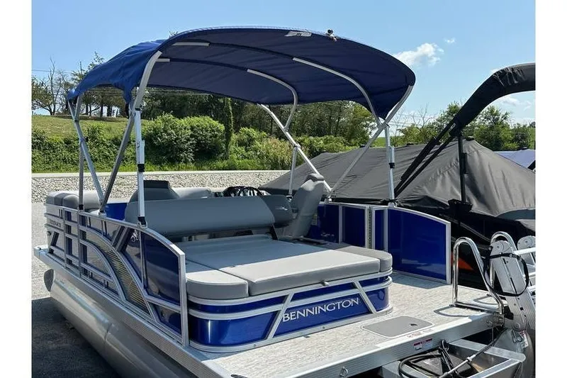 Slide: The Image of 2026 Bennington 20 SSB Swing Back pontoon boat with blue canopy and seating. - 23