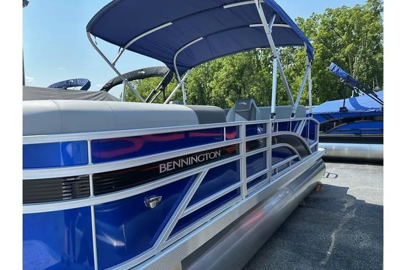 Slide: The Image of 2026 Bennington 20 SSB Swing Back pontoon boat with blue canopy and sleek design. - 7