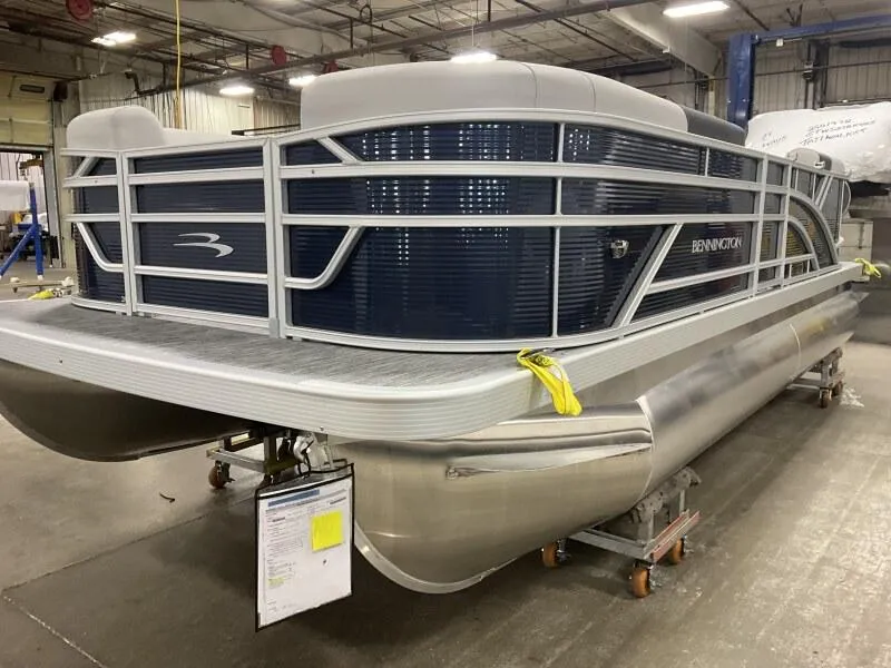 Slide: The Image of 2025 Bennington 20 SSR Quad Bench pontoon boat in stock, displayed in a showroom. - 11