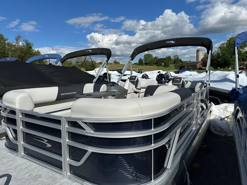 Slide: The Image of 2025 Bennington 20 SSR Quad Bench pontoon boat under a blue sky. - 20