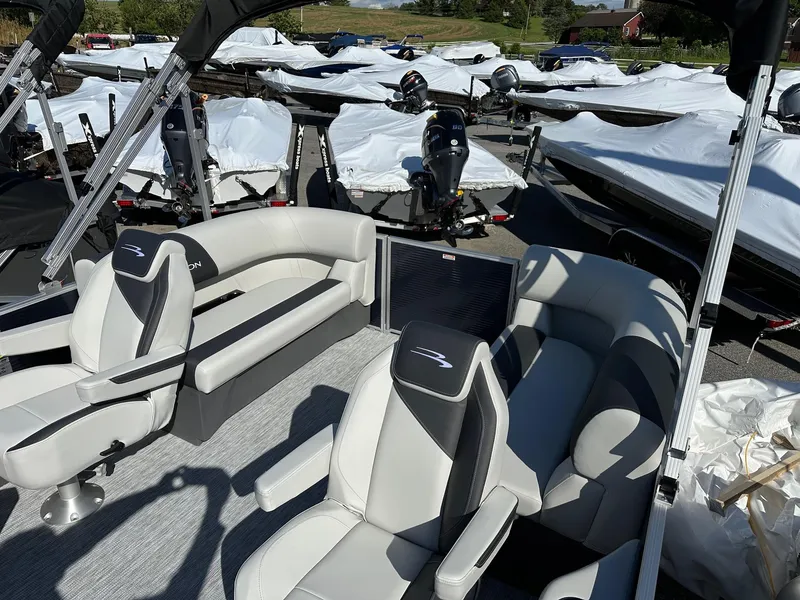 Slide: The Image of 2025 Bennington 20 SSR Quad Bench pontoon boat with sleek seating, parked outdoors. - 26